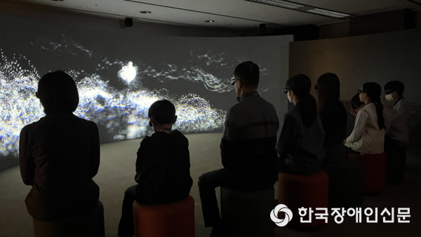 공간 오감 - 들어보다(청각) 체험 모습으로 영상 앞에서 많은 사람들이 감상하고 있는 모습이다. 