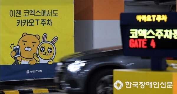 카카오모빌리티 코엑스주차장 (사진 : 한국사회보장정보원) / 사진 내 현수막 문구 이젠 코엑스에서도 카카오T주차 / 전광판 문구 카카오T주차 코엑스주차장 GATE 4